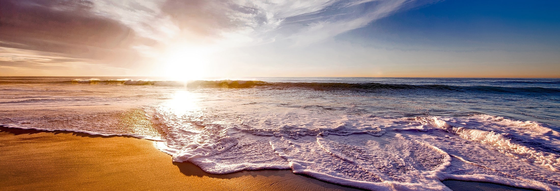 Waves crashing into a beach at sunset